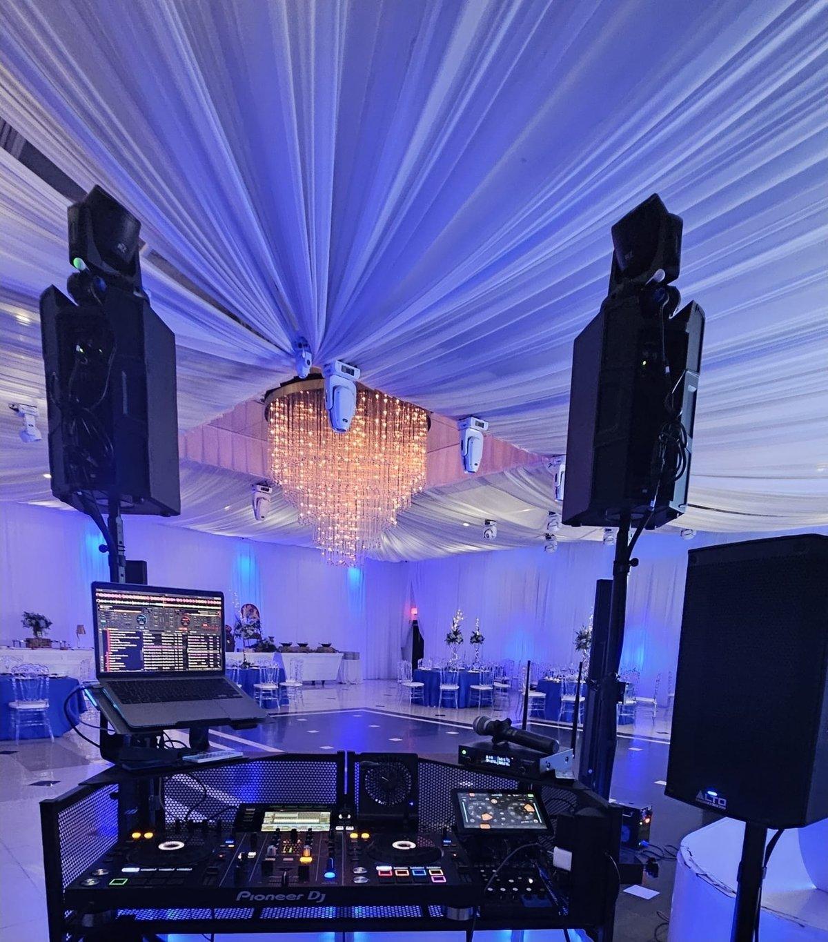 Montaje de DJ Calmet con luces y bocinas bajo el candelabro del salón
