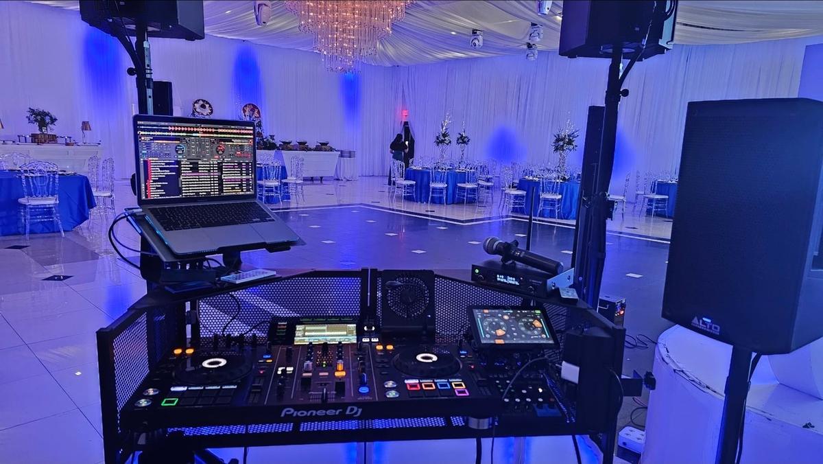 Cabina de DJ Calmet frente a la pista en un salón decorado en azul